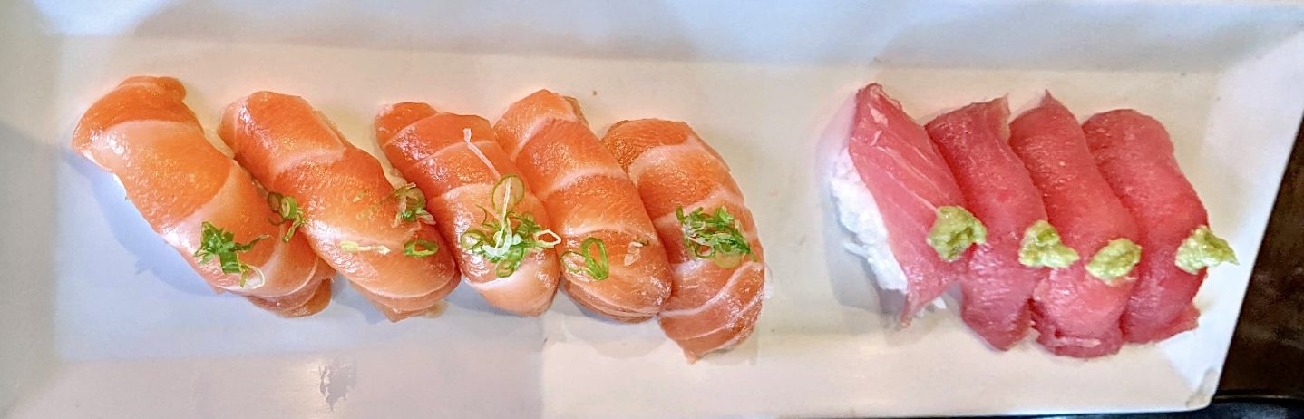 salmon nigiri with green onions and tuna nigiri with wasabi