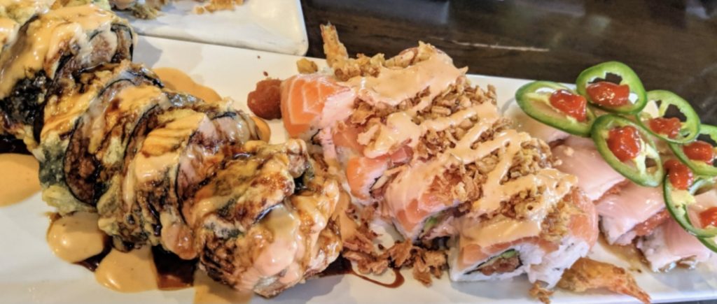 Crunch rolls and a yellowtail roll with jalapeño on top