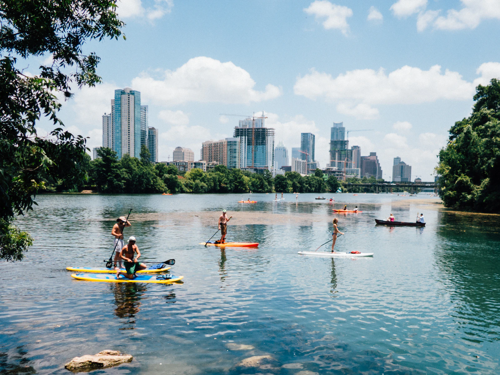 People kayaking and paddle boarding in Austin, Texas river on a sunny day