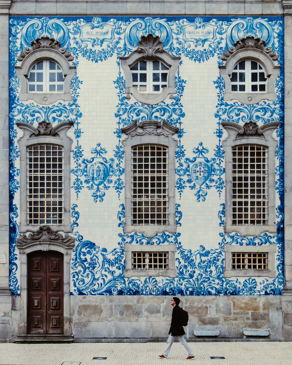Man walking next to blue building in Porto, Portugal