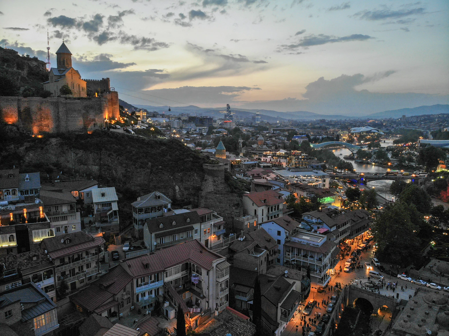 Sun setting over Tbilisi, Georgia with buildings and river below